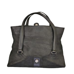 May include: A black leather tote bag with two top handles and a single snap closure.