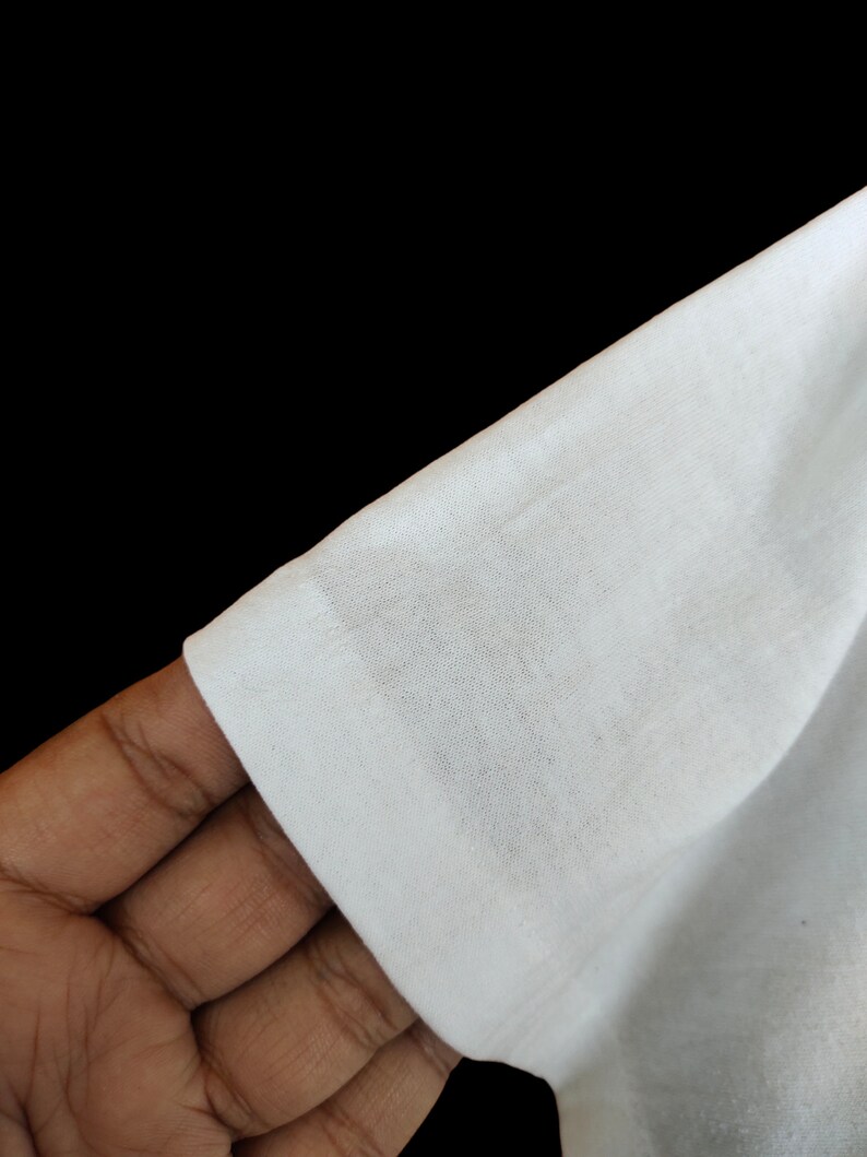 May include: Close-up of a white cotton fabric, showing the texture and weave of the material.