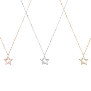 All three color options of the solid gold necklace with a diamond star charm and a thin cable chain. Rose, white and yellow gold, every option displayed right next to each other on a white background.