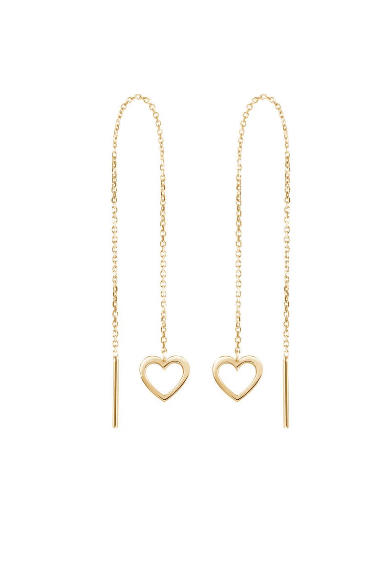 Displayed on a white background, a threader earring with a dangling heart outline on one end in yellow gold.