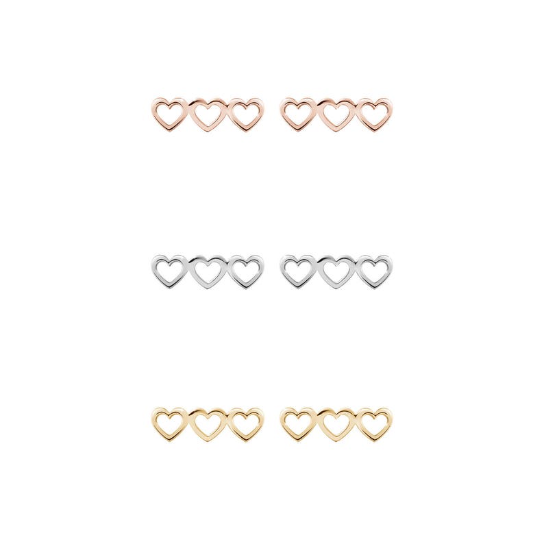 All three color options of the solid gold three-heart outline stud earrings. Rose, white and yellow gold, every option displayed right next to each other on a white background.