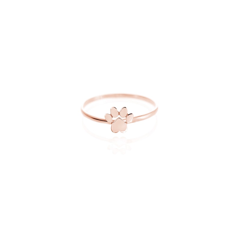 Puede incluir: Un anillo de oro rosa con un dise&ntilde;o de huella de pata.