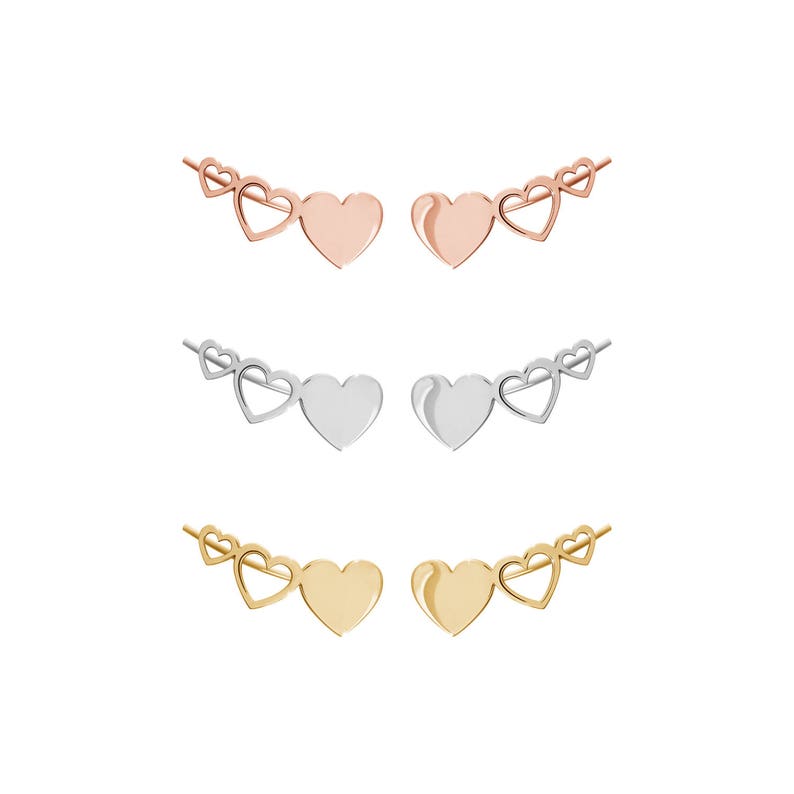 All three color options of the solid gold pair of different sized three heart climber earrings with the biggest of the hearts being solid and the outline of the other two. Rose, white and yellow gold, every option displayed on a white background.