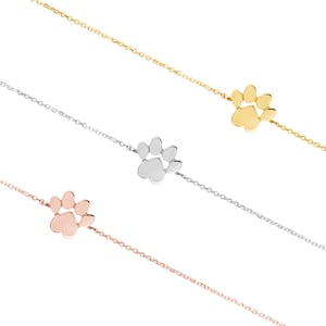 All three color options of the paw print bracelet with an adjustable chain in yellow, white and rose gold.