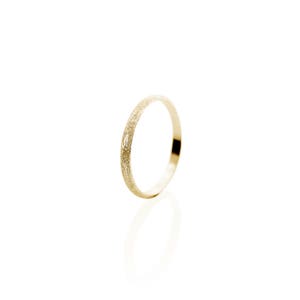 May include: A thin gold band ring with a textured finish.
