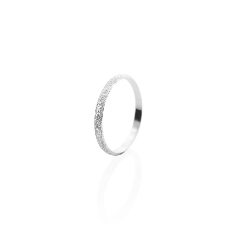 May include: A thin silver band ring with a textured finish.