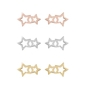 All three color options of the solid gold pair of different-sized two-star outline stud earrings. Rose, white and yellow gold, every option displayed right next to each other on a white background.