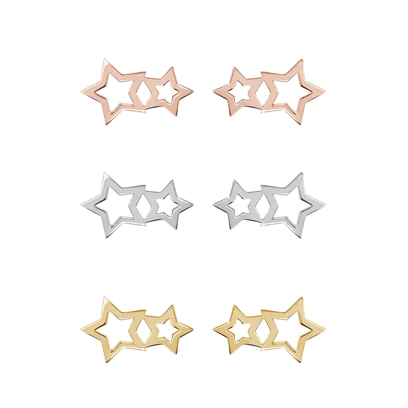 All three color options of the solid gold pair of different-sized two-star outline stud earrings. Rose, white and yellow gold, every option displayed right next to each other on a white background.