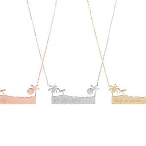 All three color options of the solid gold necklace with an engraved bar that resembles a beach, a palm tree on each side an umbrella on the left, and the sun on the right. Rose, white and yellow gold, every option displayed on a white background.