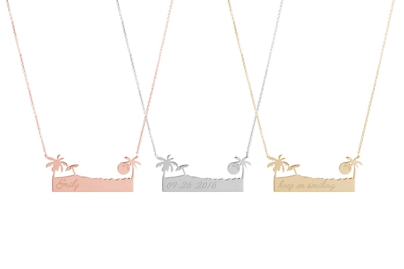 All three color options of the solid gold necklace with an engraved bar that resembles a beach, a palm tree on each side an umbrella on the left, and the sun on the right. Rose, white and yellow gold, every option displayed on a white background.