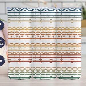 May include: Three white insulated tumblers with a repeating geometric pattern in blue, gold, orange, and green. The design features horizontal bands of various shapes and lines. The tumblers have silver lids. Each tumbler is approximately 20 cm tall.