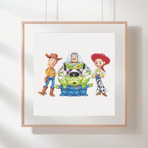May include: A framed print featuring the characters Woody, Buzz Lightyear, Jessie, and the three-eyed aliens from the animated film Toy Story. The characters are depicted in their signature outfits and poses, set against a white background.