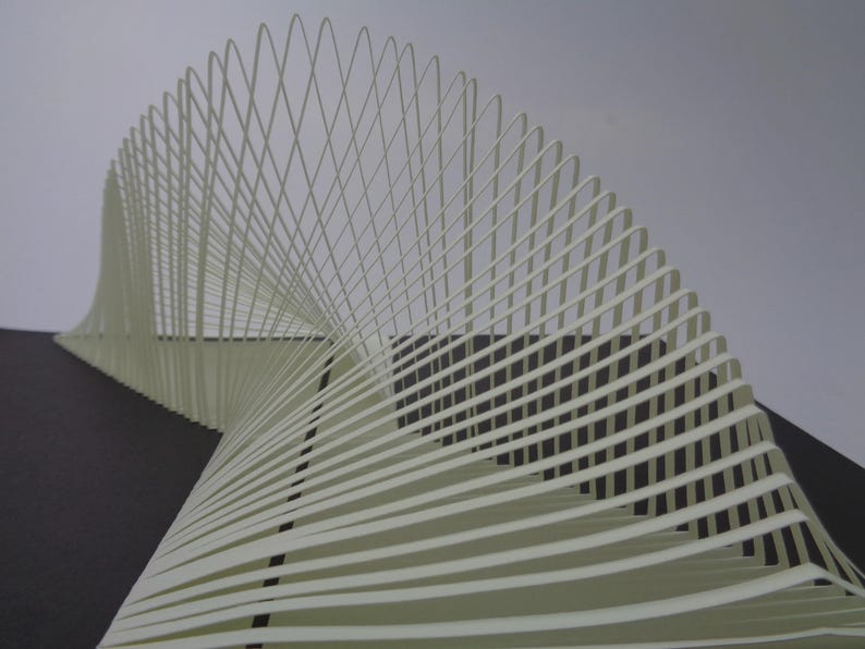 May include: Abstract sculpture composed of layered, off-white paper strips. The strips curve and intersect, creating a dynamic, three-dimensional form. The sculpture is set against a neutral background, highlighting its intricate design.
