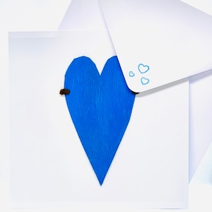 Corazón azul sobre tarjeta blanca