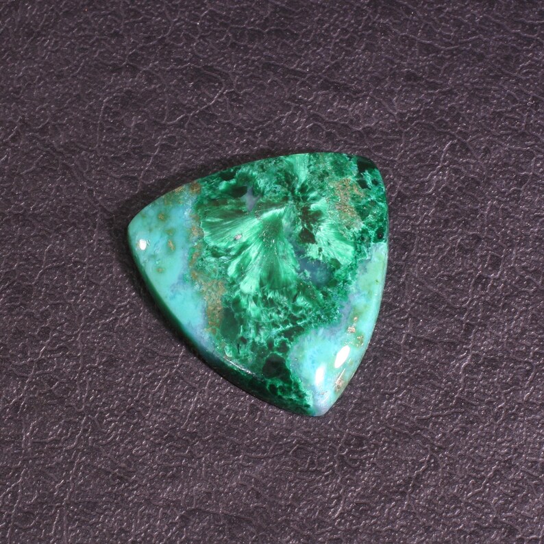 Puede incluir: Una piedra preciosa cabuj&oacute;n triangular verde y azul con un patr&oacute;n de remolino. La piedra preciosa est&aacute; engastada en un engaste plateado.