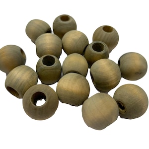 May include: A collection of unfinished wooden beads in various sizes. The beads are round with a hole drilled through the center, and have a natural, light brown color. These beads are suitable for jewelry making and craft projects.