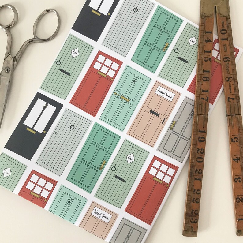 May include: White wrapping paper with a repeating pattern of colorful doors. The doors have different colors, including red, green, and blue. Some doors have the number "One" written on them. The text "Twenty Seven" appears on two of the doors.