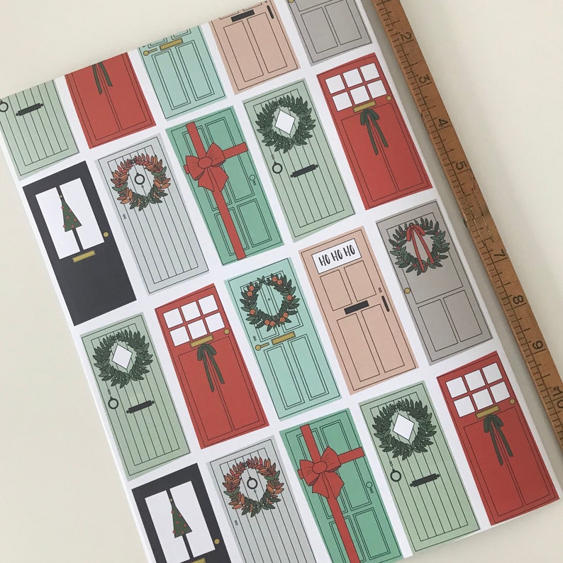 K&ouml;nnte beinhalten: Ein festliches Geschenkpapier mit einem sich wiederholenden Muster aus roten, gr&uuml;nen und wei&szlig;en T&uuml;ren mit Stechpalmenkr&auml;nzen und dem Text "Ho Ho Ho".