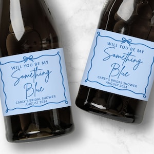 May include: Two blue and white favor labels with the text "Will you be my Something Blue" and "Carly's Bridal Shower August 2024".