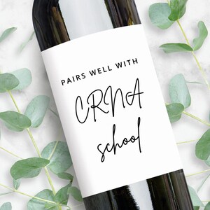 Peut inclure: Une bouteille de vin blanc avec une &eacute;tiquette qui dit "Pairs well with CRNA school".