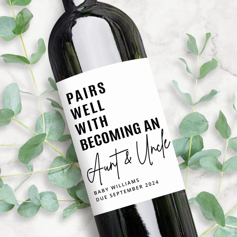 Op de afbeelding: Een wit wijnfleslabel met zwarte tekst die "Pairs well with becoming an Aunt & Uncle" luidt, met de tekst "Baby Williams Due September 2024" eronder.