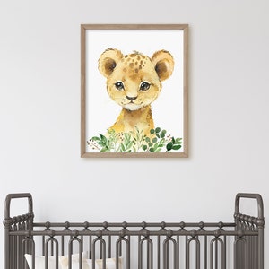 Puede incluir: Una pintura de acuarela de un lindo cachorro de le&oacute;n con hojas verdes a su alrededor. La pintura est&aacute; enmarcada en un marco de madera marr&oacute;n claro.