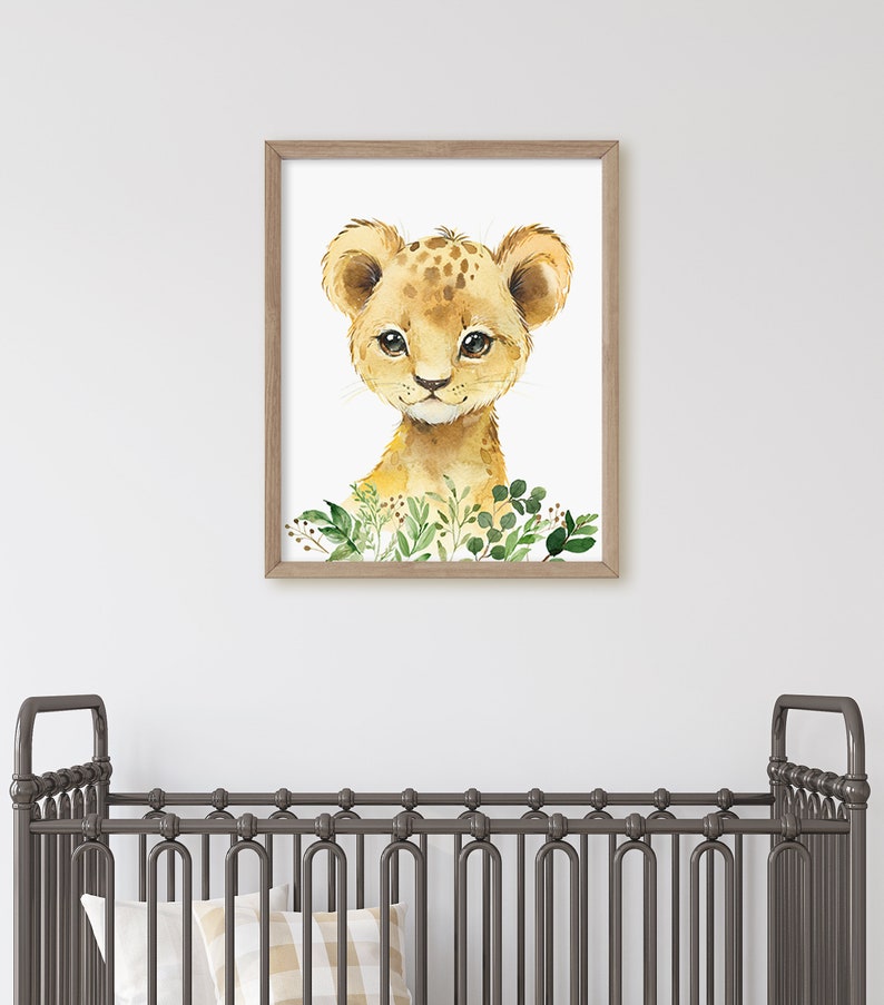 Puede incluir: Una pintura de acuarela de un lindo cachorro de le&oacute;n con hojas verdes a su alrededor. La pintura est&aacute; enmarcada en un marco de madera marr&oacute;n claro.