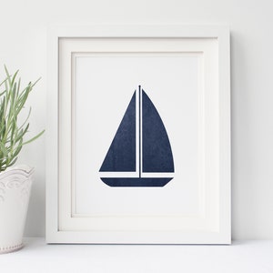 May include: A framed print of a navy blue sailboat silhouette on a white background.