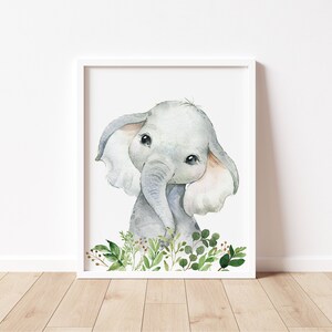 Puede incluir: Una pintura de acuarela de un elefante beb&eacute; con orejas grandes y ojos grandes. El elefante est&aacute; rodeado de hojas y ramas verdes.