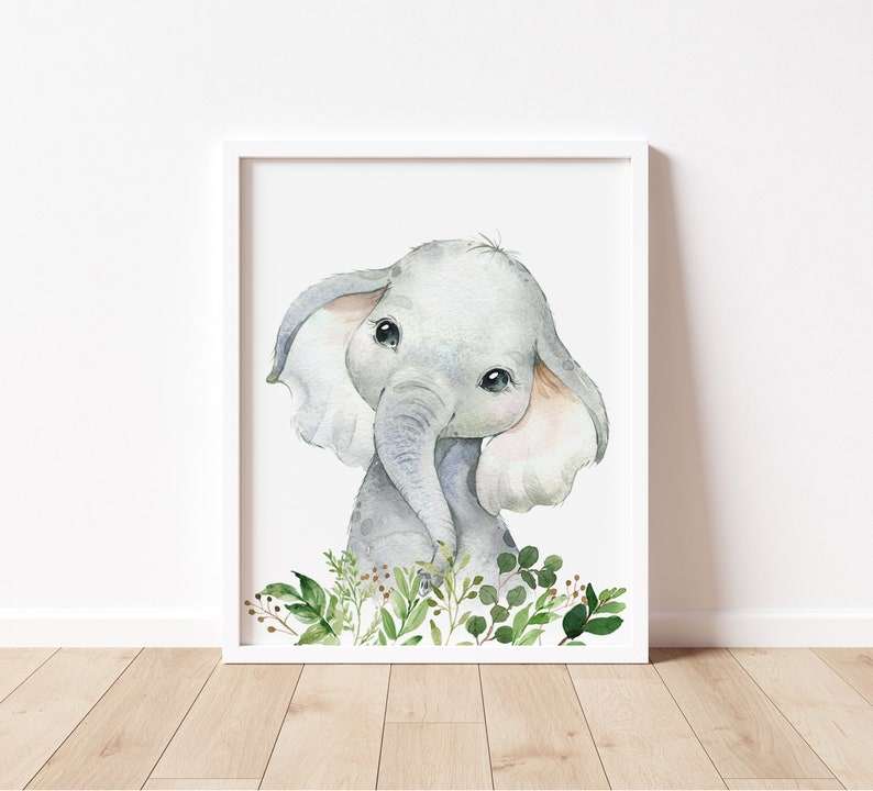 Puede incluir: Una pintura de acuarela de un elefante beb&eacute; con orejas grandes y ojos grandes. El elefante est&aacute; rodeado de hojas y ramas verdes.