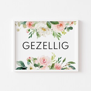 May include: White framed print with a floral design in shades of pink and green. The text "GEZELLIG" is printed in black in the center of the print.