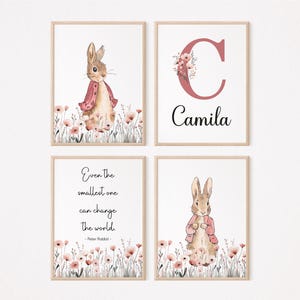 Può includere: Quattro stampe incorniciate a tema Peter Rabbit. Due stampe mostrano Peter Rabbit con una giacca rosa tra i fiori. Una stampa ha la lettera "C" con accenti floreali e il nome "Camila". La quarta stampa ha una citazione.