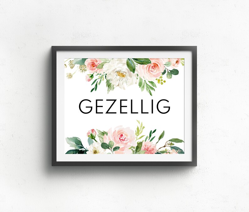 May include: A framed print with a white background and the word "GEZELLIG" in black text. The print is decorated with a watercolor floral border of pink and white flowers and green leaves.