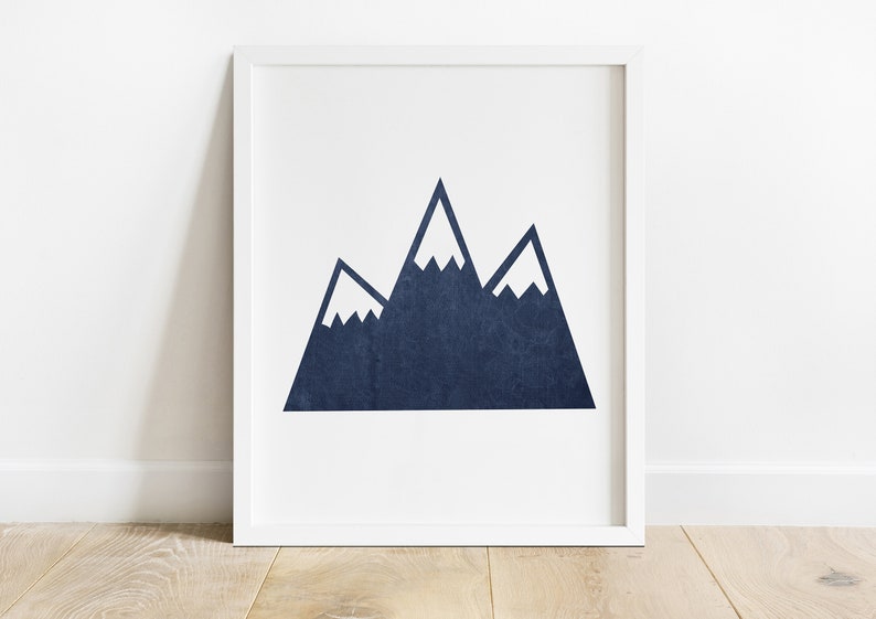 May include: A framed print of a navy blue mountain range with white snow peaks. The mountains are stylized and simple, with a minimalist design.