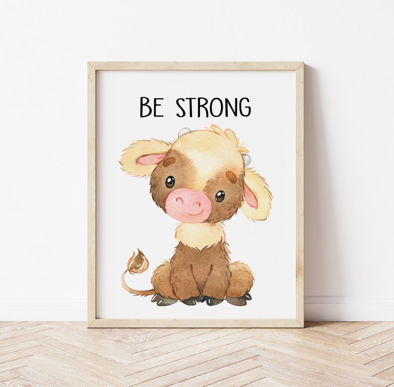 May include: A watercolor illustration of a brown and white calf with the text "BE STRONG" above it. The calf is sitting with its legs crossed and has a sweet expression on its face.