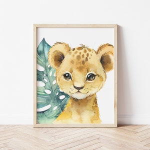 K&ouml;nnte beinhalten: Ein Aquarellbild eines niedlichen L&ouml;wenjungen mit braunem Fell und gr&uuml;nem Laub im Hintergrund.