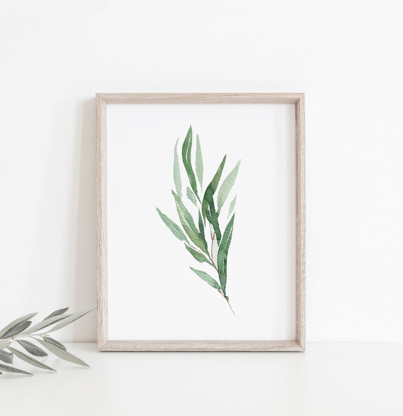 May include: A framed watercolor print of a green leafy branch with a white background.