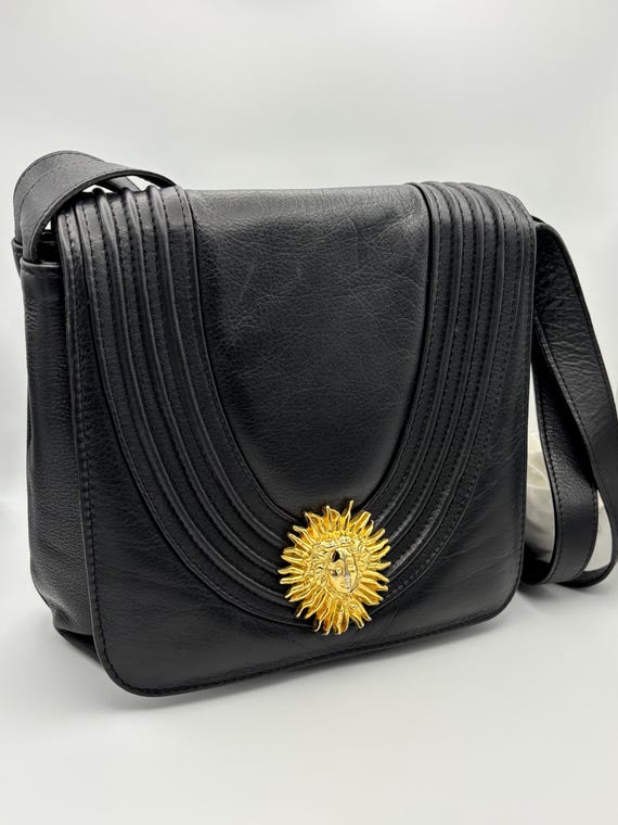 80s vintage black leather crossbody bag with a gold plated sun centre piece