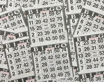 May include: A close-up of several bingo cards with numbers and the word "Bingo" printed on them. The cards are stacked on top of each other and some are partially obscured.