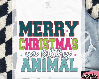 May include: White t-shirt with the text "MERRY CHRISTMAS ya filthy ANIMAL" in teal, pink, and green. The shirt also has snowflakes and the words "SVG - DIGITAL DOWNLOAD" at the bottom.