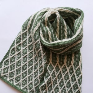May include: A green and white striped knitted scarf with a diamond pattern. The scarf is folded and tied in a knot.