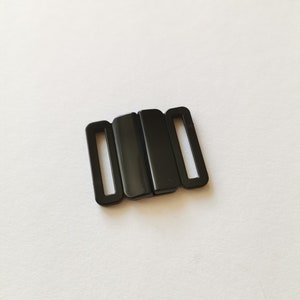 Può includere: Chiusura per reggiseno in plastica nera con tre pezzi che si incastrano.