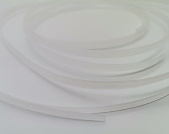 Può includere: Primo piano di un tubo bianco, flessibile e trasparente. Il tubo è avvolto e sembra essere fatto di un materiale morbido.