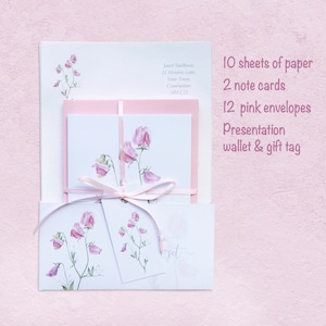 May include: A set of stationery featuring a watercolor illustration of pink sweet pea flowers. The set includes 10 sheets of paper, 2 note cards, 12 pink envelopes, a presentation wallet, and a gift tag.