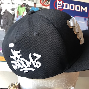 Custom black snapback cap with white fat lace and MF Doom logo. Hip hop