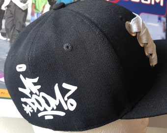 Gorra snapback personalizada de MF DOOM con cordón ancho y el logotipo de MF Doom. Hip hop.