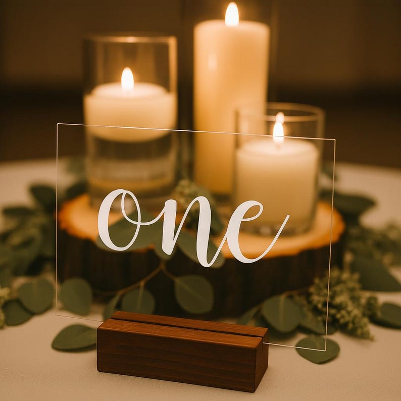 Frosted acrylic wedding table number with black lettering in wood stand, minimal and elegant centerpiece accent