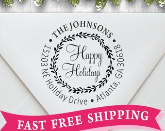 May include: A black and white round rubber stamp with the text "THE JOHNSONS 15203 NE Holiday Drive Atlanta, GA 30618" around a wreath with the text "Happy Holidays" inside.