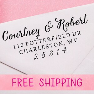 May include: A white envelope with a black return address stamp that reads "Courtney & Robert 110 Potterfield Dr Charleston, WV 25314". The envelope has a pink background with the words "FREE SHIPPING" printed in white.