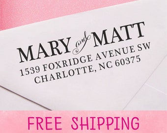 May include: A white envelope with a black return address label that reads "MARY and MATT 1539 FOXRIDGE AVENUE SW CHARLOTTE, NC 60375". The envelope has a pink background with the words "FREE SHIPPING" printed in pink.
